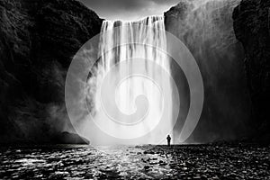 Skogafoss waterfall with a lonely man photo