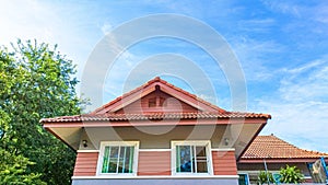 sky above house roof with tree leaves