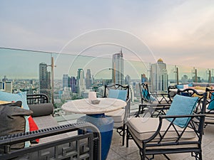 Sky bar, a restaurant or cafe lounge terrace with dinner table on rooftop of hotel, high rise architecture building with city view