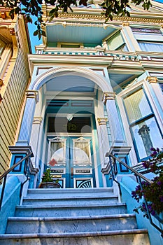 Sky blue house of The Painted Ladies entrance with red flower and 712 above Victorian doors