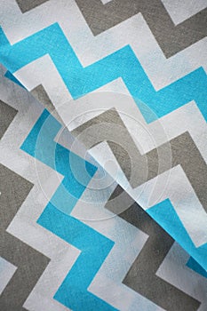 Sky blue, white and grey chevron pattern fabric sample. Fabric background