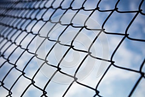 Sky through chain link fence in bokeh background, wallpaper.