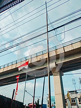 the sky in a city LRT rails with national flags below them. Palembang, Indonesian August 14, 2023