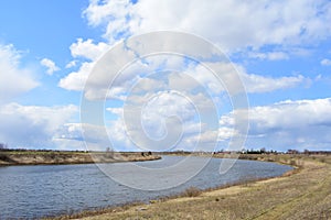 Sky, clouds. meandering river. Boundless field. A village in the distance. Rural view of nature