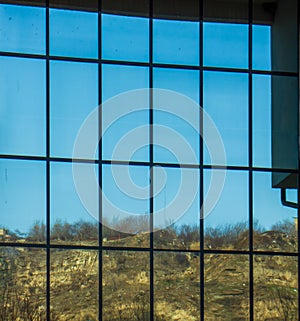 Sky and clouds reflected in windows of modern building