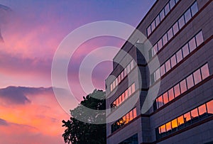 Sky with clouds reflected in windows of modern office building. Business background