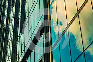 Sky with clouds reflected in windows of modern office building. Colorful background