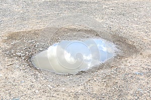 Sky with clouds reflection in water puddle