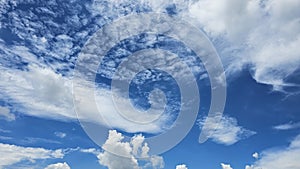 The clouds are fluffy and white against a backdrop of deep blue. photo