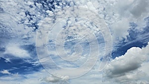The clouds are fluffy and white against a backdrop of deep blue. photo