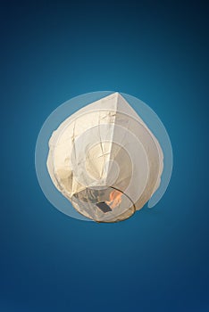 Sky Lantern in day light. White color thai sky lantern floating in blue sky.