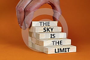 Sky is limit symbol. Concept words The sky is the limit on wooden blocks. Businessman hand. Beautiful orange table orange