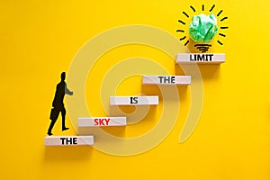 Sky is limit symbol. Concept words The sky is the limit on wooden blocks. Businessman icon. Beautiful yellow table yellow
