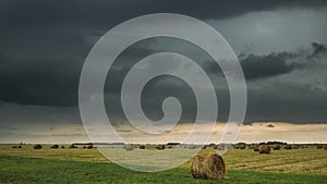 Sky Before Rain With Rain Clouds On Horizon Above Rural Landscape Field Meadow With Hay Bales After Harvest. Time Lapse