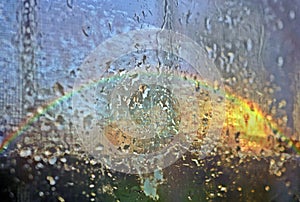 Sky with rainbow behind the glass wet with drops after rain Abstract natural photo of rainbow, rainbowscape