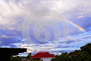 Sky with rainbow over rural houses landscape of Thailand in the evening after rain