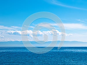 Sky, sea and mountainous island.