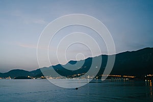 The sky after sunset over Budva in Montenegro, the lights of the night city.