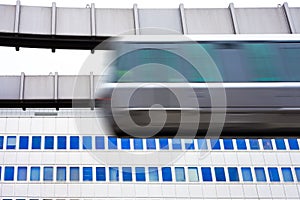 Sky-Train passing fast in front of office building