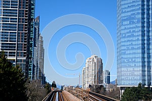 sky train road from Surrey to Vancouver passing trains skyscrapers office buildings science center and other stations