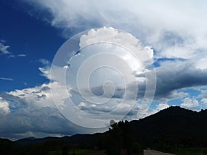 Sky with white rainy clouds in the green farmland. close up view of cloud,