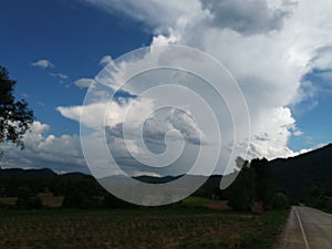 Sky with white rainy clouds in the green farmland. close up view of cloud,