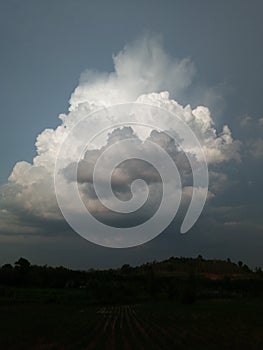 Sky with white rainy clouds in the green farmland. close up view of cloud,