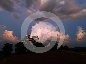 Sky with white rainy clouds in the green farmland. close up view of cloud,