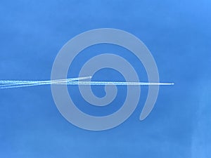 Sky with white smoke trails of flying plane