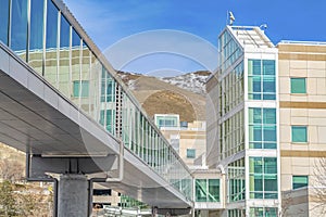 Skybridge connected to a modern building with mountain and blue sky background