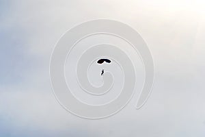 Skydiver with blue little canopy of a parachute on the background a blue sky and white clouds