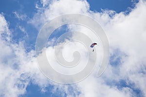 Skydiver among the clouds and blue sky photo