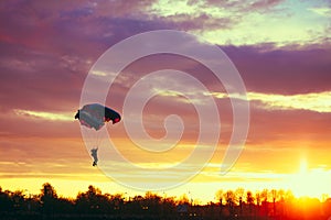 Skydiver On Colorful Parachute In Sunny Sky