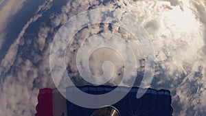 Skydiver in helmet parachuting in cloudy sky. Height. Prepare to landing. Speed.