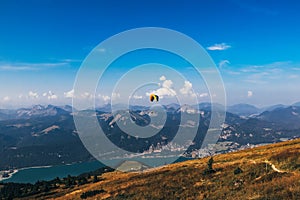 Skydiver with his colorful parachute flies over Lake Wolfgangsee in Upper Austria near the city of Salzburg. Starting position on