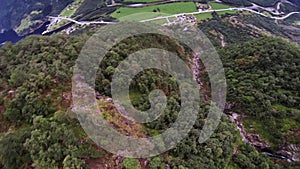 Skydiver parachuting above mountains covered by green trees. Extreme. Danger