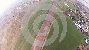 Skydiver parachuting in cloudy sky above green field. Height. Landscape. Sun