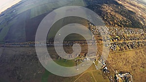 Skydiver parachuting in sky above green land. Extreme sport. Landscape. Wind