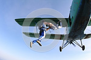 Skydivers have jumped out of a green biplane.