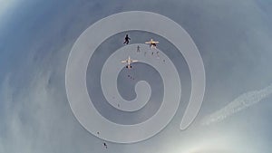 Skydivers jump from airplane falling in blue sky. Make formation. Sun. Extreme