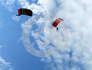 Skydivers jump from an airplane in the sky.