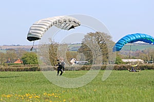 Skydivers landing in a field