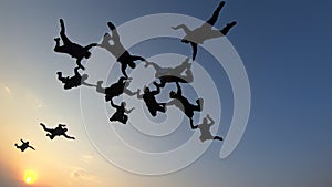 Silhouette of a group of skydivers jumping at the end of the day.