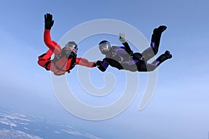 Skydiving in the blue sky.. Two skydivers send hello. photo