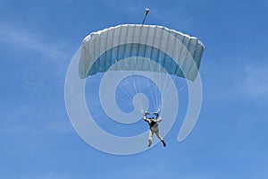 Skydiving. A parachute is in the sky.