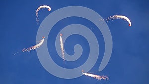 Skydiving parachutists with light flares.