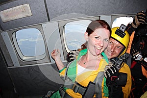 Skydiving. A passenger and her instructor in an airplane.