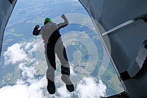 Skydiving. A skydiver is jumping out of a plane.