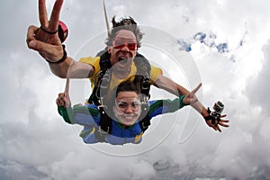 Skydiving tandem having fun on a cloudy day.