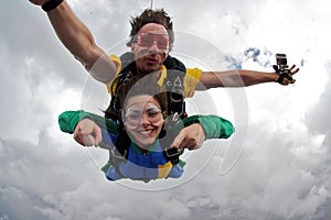 Skydiving tandem having fun on a cloudy day. photo